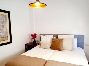 1 dormitorio con 1 cama con sábanas y almohadas blancas en Espectacular Villa PISCINA PRIVADA Altaona GOLF, en Murcia