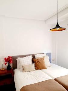Schlafzimmer mit einem Bett mit weißer Bettwäsche und Kissen in der Unterkunft Espectacular Villa PISCINA PRIVADA Altaona GOLF in Murcia