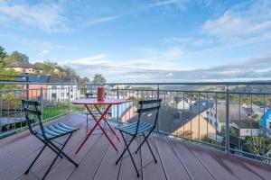 una mesa roja y sillas en un balcón con vistas en Franze´s Haus - mit Rhein- & Burgenblick, en Boppard