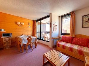 ein Wohnzimmer mit einem Sofa und einem Tisch in der Unterkunft Appartement Les Menuires, 2 pièces, 6 personnes - FR-1-344-400 in Les Menuires
