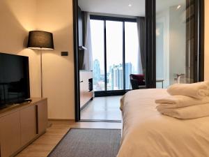 a bedroom with a bed and a tv and a window at Edge Central Pattaya By Alice in Pattaya