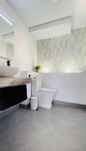 een witte badkamer met een toilet en een wastafel bij Apartamento cielomar in Aguadulce