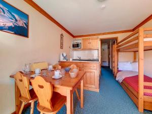 a kitchen and dining room with a table and a bed at Appartement 2 pièces ski aux pieds avec balcon - 4 personnes - FR-1-344-940 in Les Bruyères +6 photos