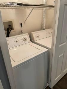 ハンプトンにあるMinutes to the beach! 4-bedroom home, free parkingの小さな部屋に白い洗濯機と乾燥機があります。