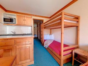 a small kitchen with a bunk bed in a room at Appartement 2 pièces ski aux pieds avec balcon - 4 personnes - FR-1-344-940 in Les Bruyères