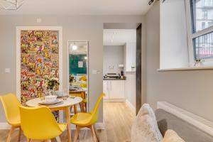a dining room with a table and yellow chairs at Spacious Luxury Service Apartment Stevenage Town Centre family or business in Stevenage