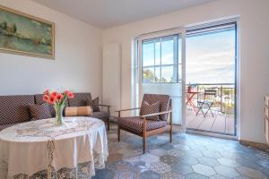 una sala de estar con una mesa con un jarrón de flores en Franze´s Haus - mit Rhein- & Burgenblick, en Boppard