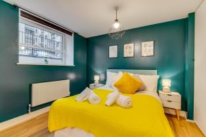 1 dormitorio con 1 cama amarilla y 2 toallas en Spacious Luxury Service Apartment Stevenage Town Centre family or business en Stevenage