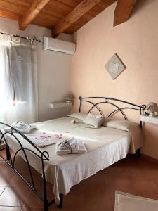 Schlafzimmer mit einem Bett mit weißer Bettwäsche und einem Fenster in der Unterkunft Donnigheddu in Rudalza