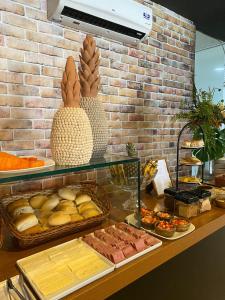 a buffet with bread and other foods on a counter at Uno Hotel in Carpina