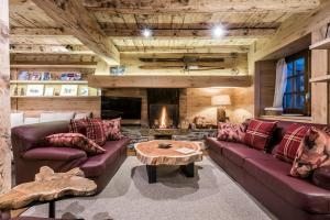 a living room with leather couches and a fireplace at Casa Pleta de Baqueira Deluxe by Totiaran in Naut Aran