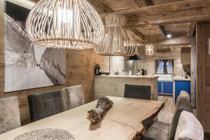 a dining room with a table and two chandeliers at Casa Pleta de Baqueira Deluxe by Totiaran in Naut Aran