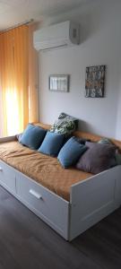 a large bed with blue pillows in a bedroom at Berik Apartman in Pécs