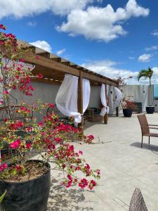 a patio with pink flowers and a umbrella at Uno Hotel in Carpina