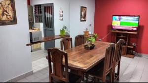comedor con mesa de madera y TV en AZUL Y LUNA en Vaqueros