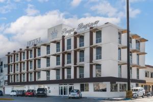 - un grand bâtiment blanc avec un panneau dans l'établissement Hotel Plaza Regina Torreon, à Torreón