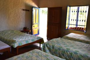a room with two beds and a window and a door at El Prado EcoHotel in Montenegro