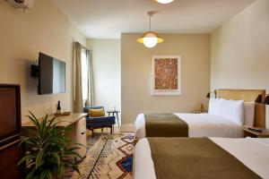 ein Hotelzimmer mit 2 Betten und einem TV in der Unterkunft Hotel Kinsley in Kingston