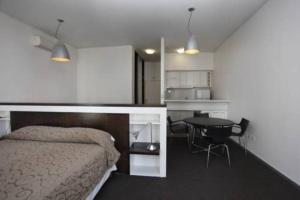 1 dormitorio con cama, mesa y cocina en San Telmo Apart: Pileta y Sauna en Buenos Aires