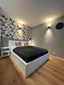 1 dormitorio con cama blanca y manta negra en Urocze studio przy Rynku, en Wroclaw