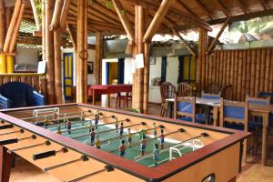a large billiard table in a room with tables and chairs at El Prado EcoHotel in Montenegro
