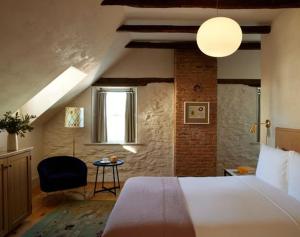 a bedroom with a bed and a chair and a window at Hotel Kinsley in Kingston