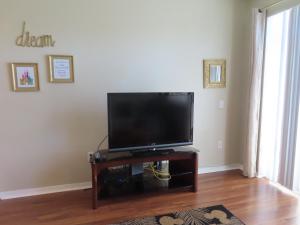 a living room with a flat screen tv on a table at Kissimmee townhome 3 miles to Disney! in Orlando