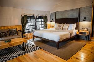 - une chambre avec un grand lit et un canapé dans l'établissement Everest Base Camp, Near George Everest House, 5kms from Library chowk, à Mussoorie