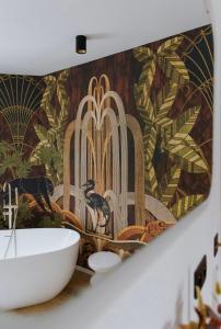 uma casa de banho com um lavatório e um mural de parede em Au Numéro 5 em Tilff
