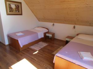 a bedroom with two beds and a wooden ceiling at Guest House Nenad in Plitvička Jezera +29 photos