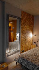 - une chambre avec un miroir et un mur en briques dans l'établissement L1apartment, à Kiev