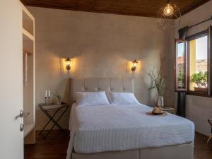 a bedroom with a bed and two lights on the wall at Casa Theano - Old Town in Rhodes Town