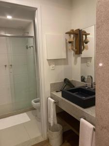 a bathroom with a sink and a toilet and a shower at Apartamento em Resort Angra dos Reis in João Neiva