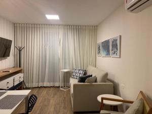 een woonkamer met een bank en een tafel bij Apartamento em Resort Angra dos Reis in João Neiva