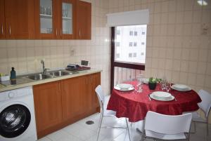 a kitchen with a table with a red table cloth at Terreiro da Erva House 2 in Coimbra