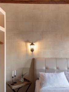 ein Schlafzimmer mit einem Bett und einer Lampe an einer Wand in der Unterkunft Casa Theano - Old Town in Rhodos (Stadt)