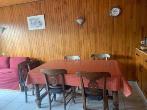 a dining room table with chairs and a clock on the wall at Appartement Châtel, 2 pièces, 5 personnes - FR-1-200-164 in Châtel