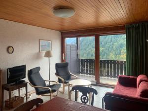 a living room with a couch and chairs and a large window at Appartement Châtel, 2 pièces, 5 personnes - FR-1-200-164 in Châtel