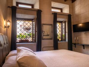 a bedroom with a bed and a window and a tv at Casa Theano - Old Town in Rhodes Town
