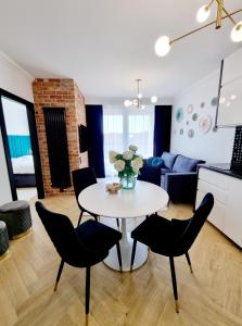 a kitchen and living room with a table and chairs at RentPlanet - Apartamenty Chlebova II in Gdańsk