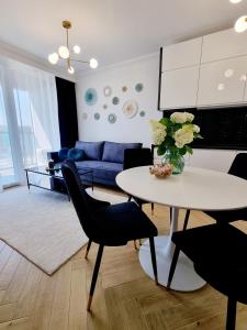 a living room with a table and a blue couch at RentPlanet - Apartamenty Chlebova II in Gdańsk
