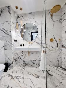 a bathroom with marble walls and a mirror at RentPlanet - Apartamenty Chlebova II in Gdańsk