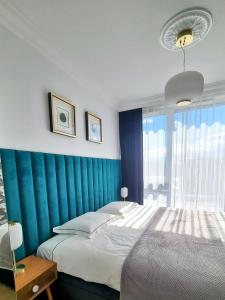 a bedroom with a bed and a blue wall at RentPlanet - Apartamenty Chlebova II in Gdańsk