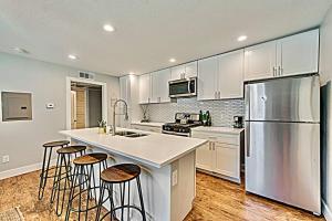 a kitchen with a stainless steel refrigerator and bar stools at The Rhythm Room Near Downtown Dallas! in Dallas