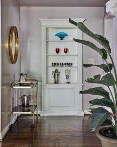 a room with a shelf with red and blue glasses at Eden Brae: Historic Southern Gothic Mansion in Birmingham