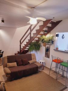 a living room with a couch and a staircase at Lindo Flat em Maresias in São Sebastião