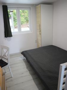 1 dormitorio con cama negra y ventana en Áfonyácska Vendégház en Mátraszentimre