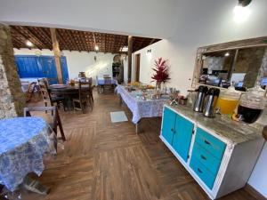 a room with two tables and a counter with blue cabinets at Pousada Refúgio Ouro Fino - Flats & Suítes in Paraty