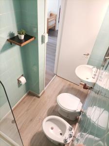 La salle de bains est pourvue de 2 toilettes et d'une douche en verre. dans l'établissement Buenaventura Apartments Terrazas, à Mendoza
