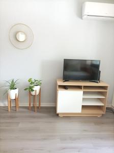 a living room with a tv and two chairs at Buenaventura Apartments Terrazas in Mendoza
